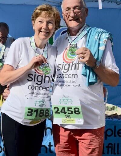two runners representing sight concern holding their medals after completing the worcester run 2019