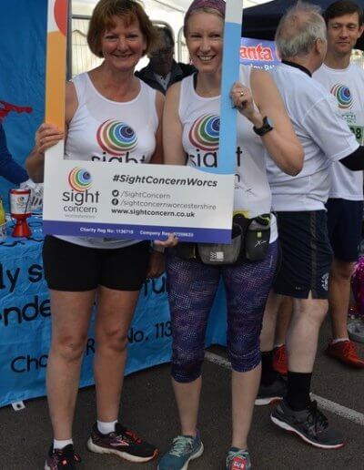 a pair of sight concern runners using a selfie board at the worcester run 2019
