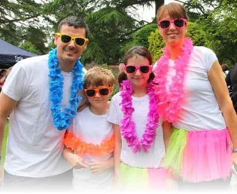 a family in brightly coloured clothes and wearing sunglasses pse for the camera