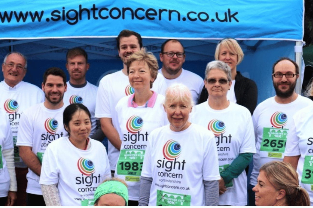 a group of people stood wearing sight concern tshirts and smiling for the camera